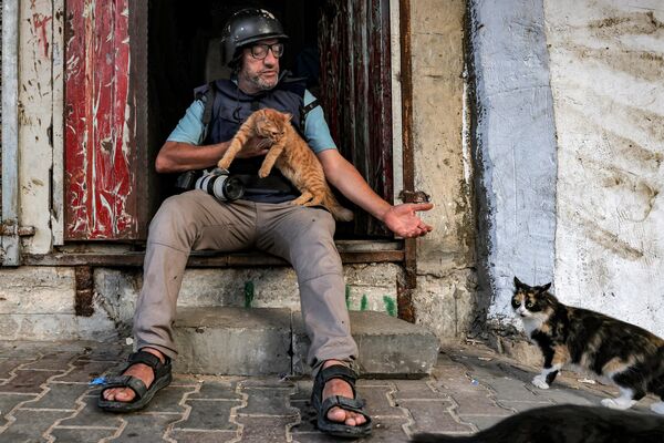 Фотограф AFP Мохаммед Абед с кошкой в Рафахе. - Sputnik Беларусь