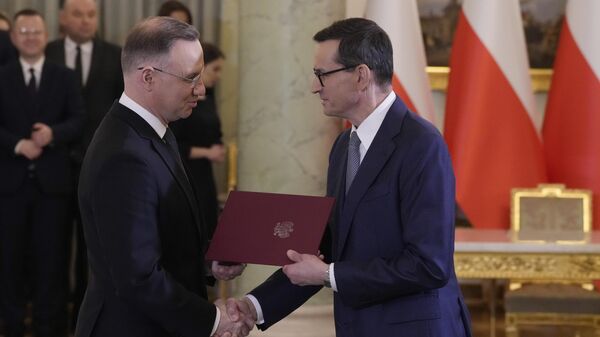 Президент Польши Анджей Дуда (слева) пожимает руку премьер-министру Матеушу Моравецкому во время церемонии приведения к присяге в Варшаве - Sputnik Беларусь