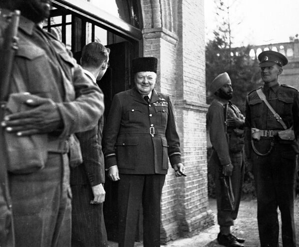 Премьер-министр Великобритании Уинстон Черчилль в каракулевой шляпе, подаренной ему британским отделом прессы в честь его 69-летия. - Sputnik Беларусь