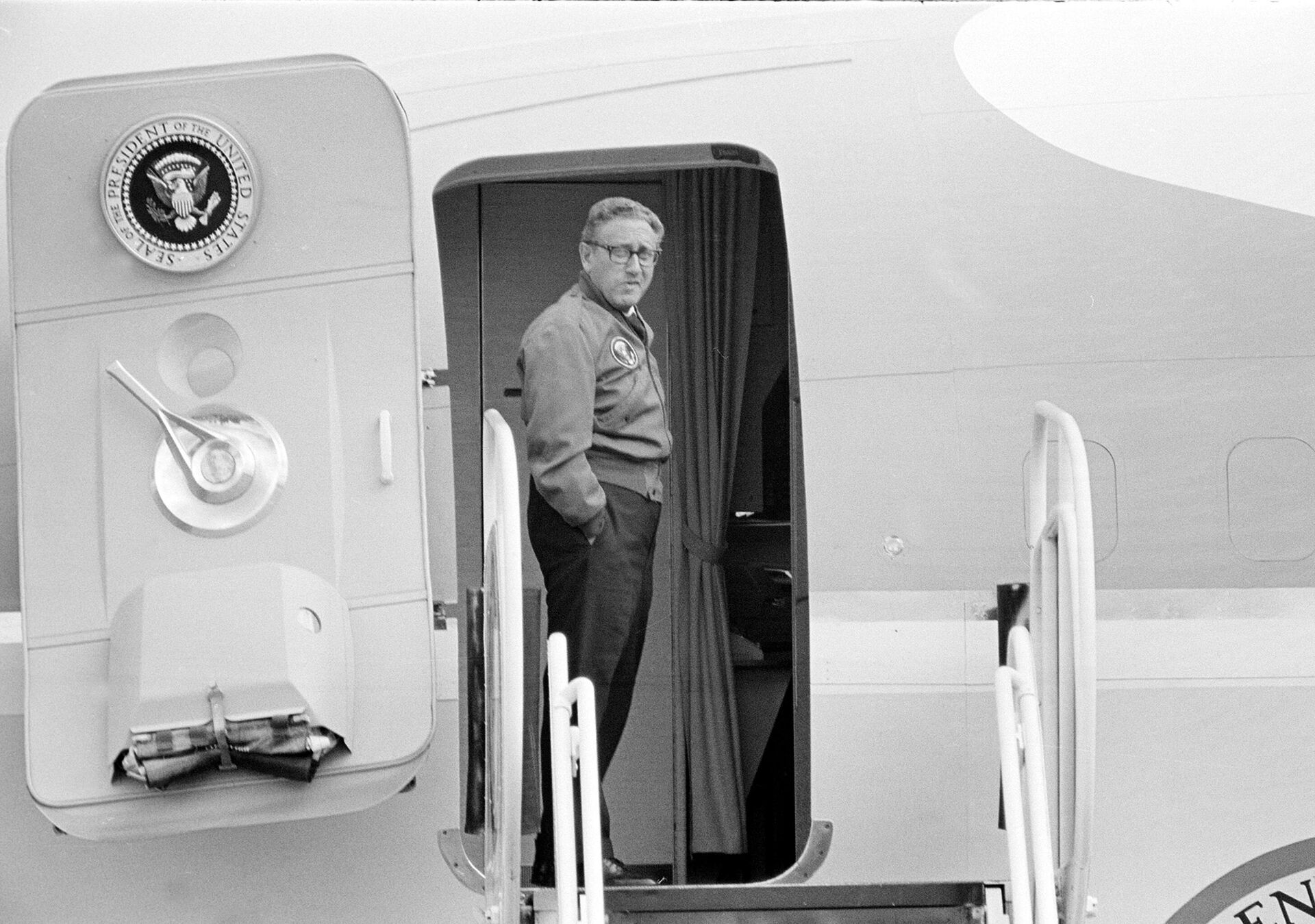 Генри Киссинджер, советник президента по национальной безопасности, ждет у дверей Air Force One, чтобы сопровождать президента в Уолла Уолла, штат Вашингтон - Sputnik Беларусь, 1920, 30.11.2023