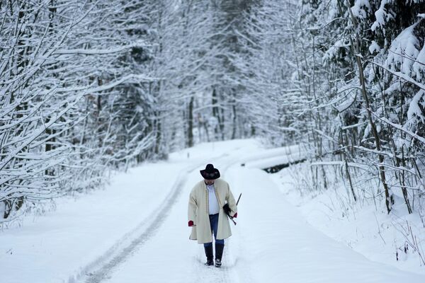Мужчина идет по заснеженной дороге недалеко от деревни Лидецко, Чехия - Sputnik Беларусь