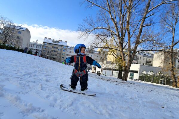 Двухлетний мальчик катается на сноуборде в парке Штайнхаге в Вене, Австрия - Sputnik Беларусь