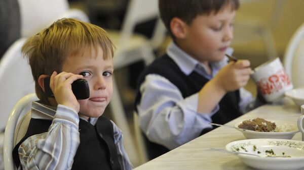 Ребенок говорит по мобильному телефону в школьной столовой - Sputnik Беларусь