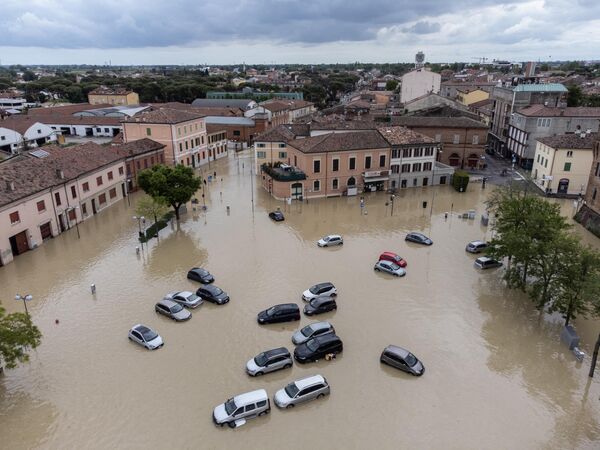 В мае 2023 года серия наводнений обрушилась на города Болонья, Чезена, Форли, Равенна и Римини и их окрестности в регионе Эмилия-Романья в Италии. Первые наводнения произошли между 2 и 3 мая, в результате их погибли два человека. Еще одна серия наводнений началась 16 мая 2023 года и продолжалось по 18 мая, в ее ходе погибло по меньшей мере 15 человек и 50 000 были вынуждены покинуть свои дома. За две недели выпала семимесячная норма осадков, что вызвало разлив 23 рек по всему региону. В некоторых районах почти половина среднегодовой нормы осадков выпала всего за 36 часов. Более того, произошло по меньшей мере 300 оползней, 43 города оказались затронуты наводнениями. По сообщениям, наводнение стало самым мощным в Италии за последние 100 лет.На фото: затопленные улицы города Луго, недалеко от Равенны, 18 мая 2023 года. - Sputnik Беларусь