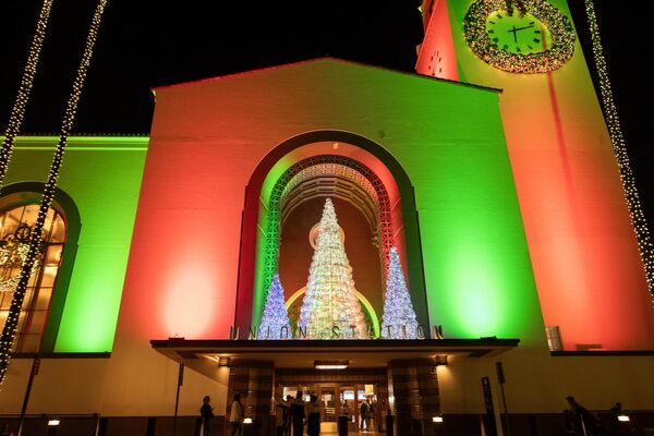 Станция Union Station в Лос-Анджелесе освещена красным и зеленым светом во время церемонии зажжения рождественской елки. - Sputnik Беларусь