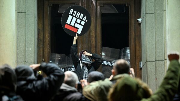 Протестующий держит плакат с надписью Борьба у входа в здание городского совета Белграда во время демонстрации в Белграде, 24 декабря 2023 года - Sputnik Беларусь