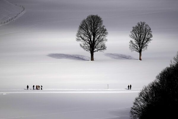 Люди идут по заснеженному ландшафту в Рамзау. Австрия, 16 декабря. - Sputnik Беларусь