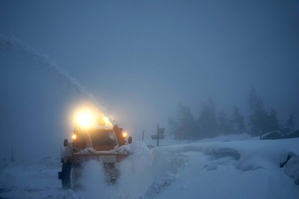 Снегоочиститель чистит дорогу на самой высокой горе Брокен в северной Германии в горах Гарц недалеко от Ширке. Германия, 21 декабря. - Sputnik Беларусь