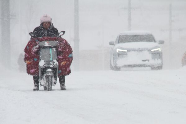 На дороге в Вэйхае, восточная китайская провинция Шаньдун, во время снегопада. Китай, 16 декабря. - Sputnik Беларусь