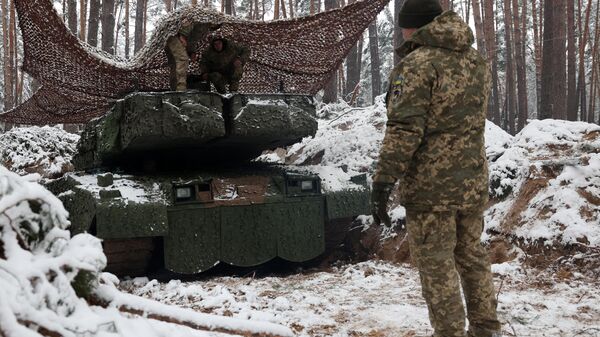 Украинский танкист стоит рядом с заснеженным боевым танком Леопард 2А5 немецкого производства - Sputnik Беларусь