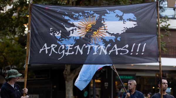 Мужчины держат флаг с изображением карты Фолклендских/Мальвинских островов с надписью Аргентинский! во время акции протеста возле посольства Великобритании в Буэнос-Айресе, архивное фото - Sputnik Беларусь