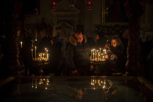Верующие Литовской православной церкви зажигают свечи перед литургией в православный сочельник в православном храме Святого Духа в Вильнюсе. - Sputnik Беларусь