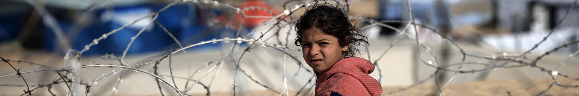 Перемещенный палестинский ребенок сидит за колючей проволокой на дюне с видом на импровизированный лагерь на границе с Египтом, к западу от Рафаха на юге сектора Газа, 14 января 2024 года - Sputnik Беларусь, 1920