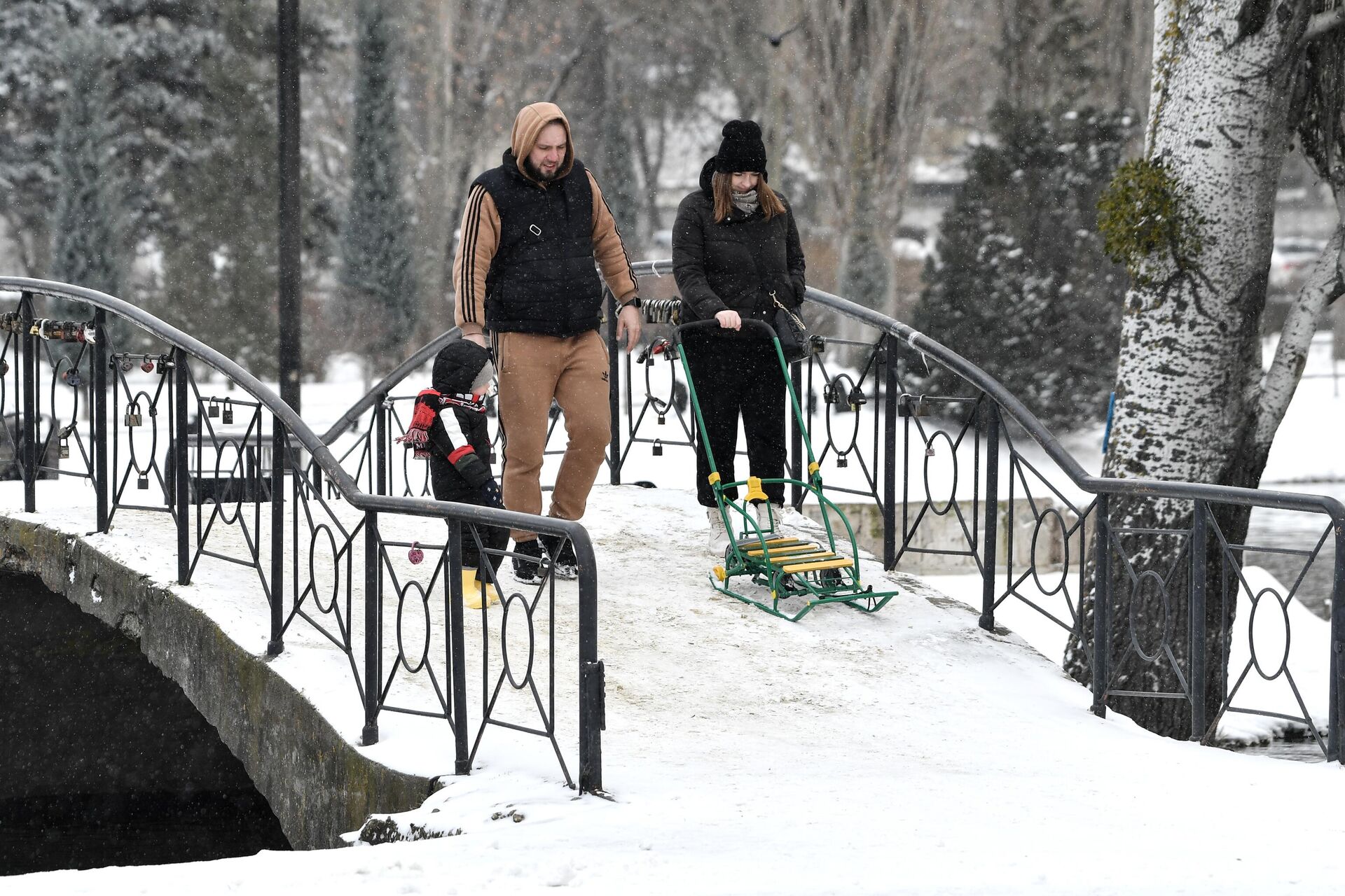 Молодая пара с ребенком гуляют в парке - Sputnik Беларусь, 1920, 27.01.2026