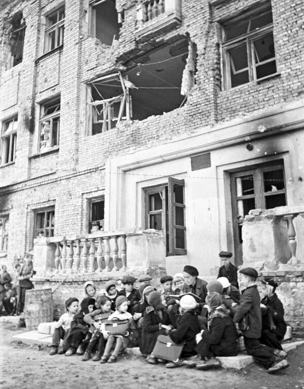 Урок на крыльце разрушенной немецкими обстрелами школы. - Sputnik Беларусь