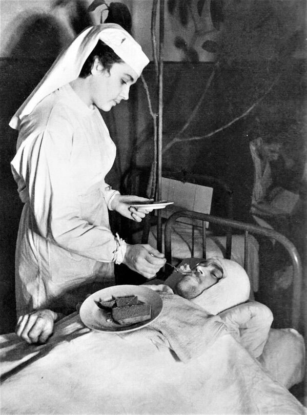 Медсестра Ленинградского Военно-морского госпиталя Анна Юшкевич кормит раненого краснофлотца - Sputnik Беларусь