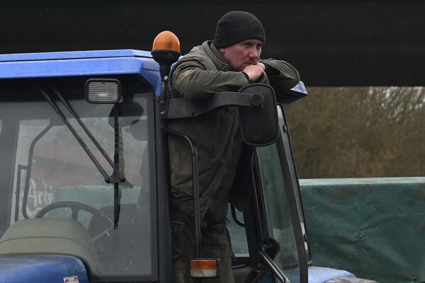 Французский фермер стоит на своем тракторе во время протестов. - Sputnik Беларусь