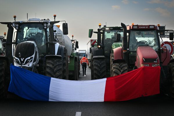 Французский флаг между двумя тракторами, блокирующими автомагистраль А7 недалеко от Альбона на юго-востоке Франции. - Sputnik Беларусь
