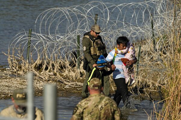 Мигранты задержаны на границе Техаса и Мексики в среду, 3 января 2024 года, в Игл-Пасс, штат Техас - Sputnik Беларусь