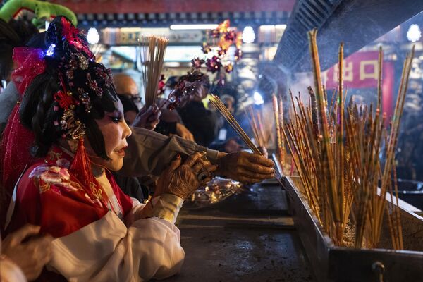 Верующие молятся, сжигая свои первые палочки для благовоний в храме, чтобы встретить Лунный Новый год Дракона в Гонконге, Китай. - Sputnik Беларусь