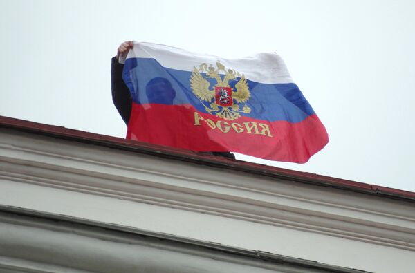 Местный житель с российским флагом на крыше Горсовета в Севастополе. 28 февраля 2014 года. - Sputnik Беларусь