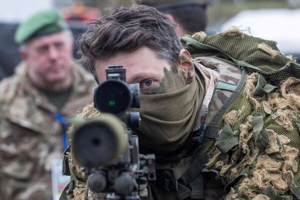 ​Британский солдат смотрит в оптический прицел снайперской винтовки. - Sputnik Беларусь