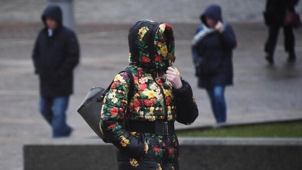 Женщина идет по улице под порывами ветра - Sputnik Беларусь