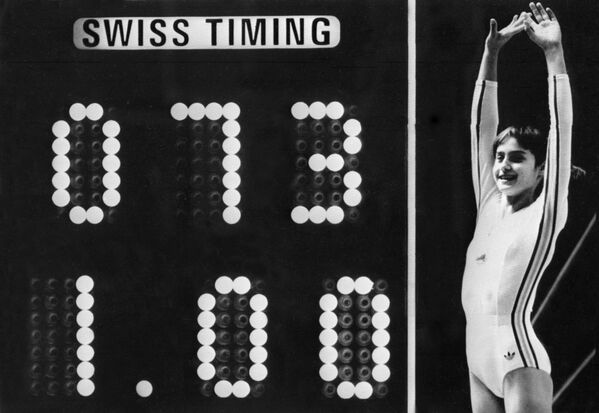 19 июля 1976 года на Олимпиаде в Монреале после обязательной акробатики на брусьях 14-летняя Надя Команечи получила десять баллов. В то время считалось, что в гимнастике получить десятку невозможно в принципе: табло было рассчитано только на 3 цифры. 10.00 баллов в итоге превратились в 1.00, и трибуны взорвались негодованием. Команечи стала первой в истории, кто получил от жюри 10 баллов на международных соревнованиях. Всего на Олимпиадах легендарная гимнастка завоевала пять золотых, три серебряных и одну бронзовую медали. Она дважды становилась чемпионкой мира и девять раз – Европы. - Sputnik Беларусь