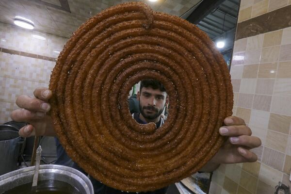 Мужчина готовит жареные сладости для ифтара в городе Аль-Баб, на севере Сирии. - Sputnik Беларусь