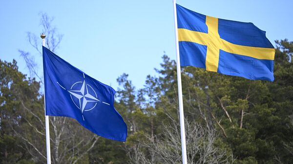 Флаг НАТО поднимается рядом с флагом Швеции (справа) на церемонии на военно-морской базе Муско в Стокгольме - Sputnik Беларусь