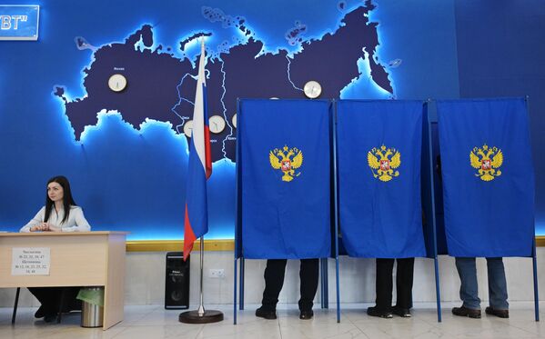 Люди голосуют на выборах президента России на одном из избирательных участков в Новосибирске - Sputnik Беларусь