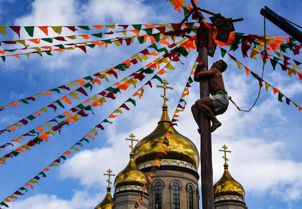 Участник лезет на столб на праздновании Масленицы во Владивостоке - Sputnik Беларусь