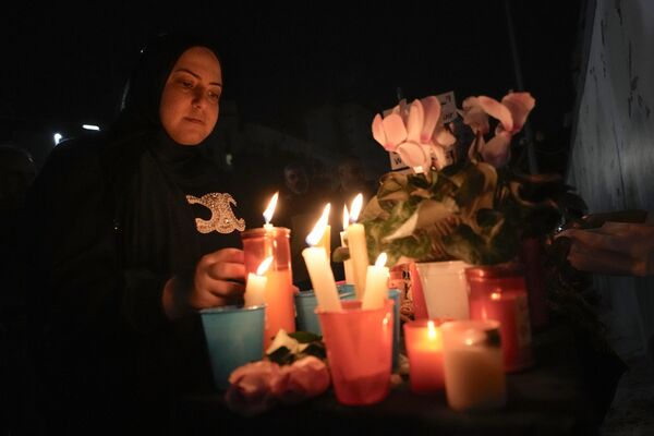 Женщина зажигает свечи возле посольства России в Бейруте - Sputnik Беларусь