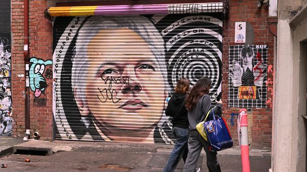 Люди проходят мимо мурала с изображением основателя WikiLeaks Джулиана Ассанжа - Sputnik Беларусь
