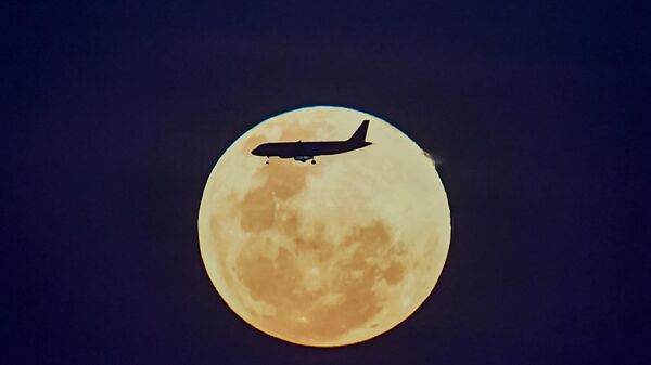 Самолет летит на фоне Луны - Sputnik Беларусь