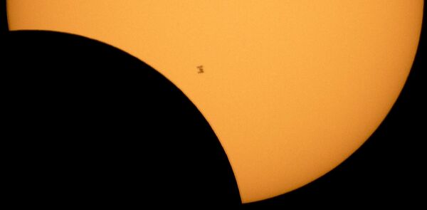 Международная космическая станция на фоне Солнца во время частичного солнечного затмения. - Sputnik Беларусь