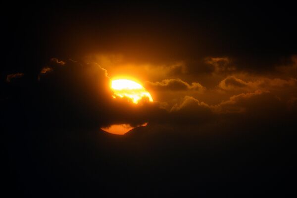 Луна начинает затмевать часть Солнца во время солнечного затмения, наблюдаемого из Виго, на северо-западе Испании. - Sputnik Беларусь