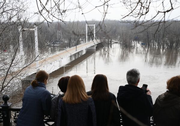 Люди смотрят на затопленный пешеходный мост &quot;Европа-Азия&quot; в Оренбурге.  - Sputnik Беларусь