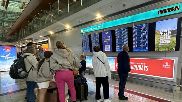 Пассажиры проверяют информацию о рейсах на экранах в международном аэропорту Дубая в Дубае 17 апреля 2024 года - Sputnik Беларусь
