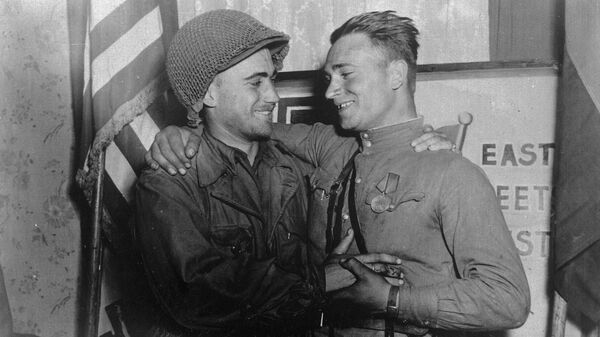 Лейтенант У. Робертсон и лейтенант А. С. Сильвашко на фоне надписи Восток встречается с Западом, символизирующей историческую встречу союзников на Эльбе - Sputnik Беларусь