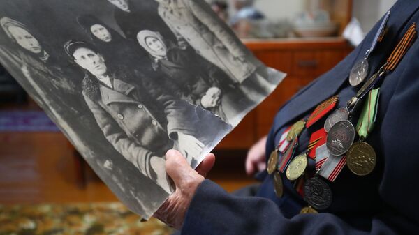 Ветеран рассматривает старую фотографию, архивное фото - Sputnik Беларусь