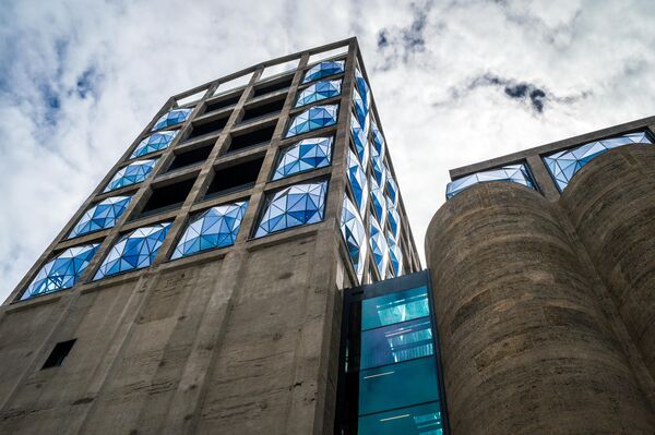 Музей современного искусства Zeitz MOCAA, Кейптаун, ЮАР.Находится в здании бывшего зернохранилища, перепланировкой которого занималось архитектурное бюро Heatherwick Studio. Здание было признано историческим памятником: это 42 башни, 33 метра в высоту и 5,5 метров в диаметре.Архитекторы постарались сохранить &quot;индустриальное наследие&quot; оригинальной конструкции. Оставшиеся бетонные конструкты закрыты прочным стеклом, чтобы позволить естественному свету проникнуть в здание и создать благодаря этому &quot;соборный&quot; интерьер.Это крупнейший музей современного африканского искусства в мире. - Sputnik Беларусь