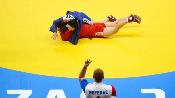 Мухлисахон Кадыберганова (Узбекистан) и Сунджидмаа Цор-Очир (Монголия) в поединке среди женщин (65 кг) соревнований по самбо спортивных игр стран БРИКС в Казани - Sputnik Беларусь