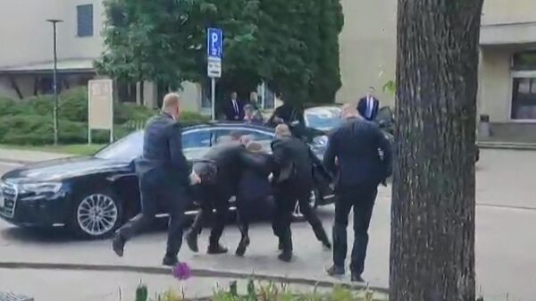 Сотрудники службы безопасности ведут премьер-министра Словакии Роберта Фицо (в центре) к автомобилю после того как он был ранен в Хандлове 15 мая 2024 года - Sputnik Беларусь