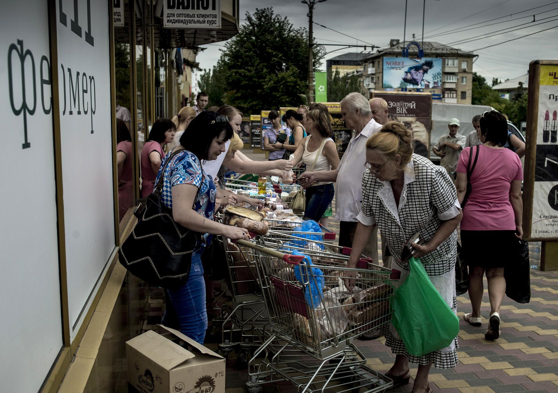 Жители Луганска покупают продукты питания. Из-за отсутствия электричества в городе продуктовые магазины продают товары на улице. 18 июля 2014 года. - Sputnik Беларусь, 1920, 13.08.2024