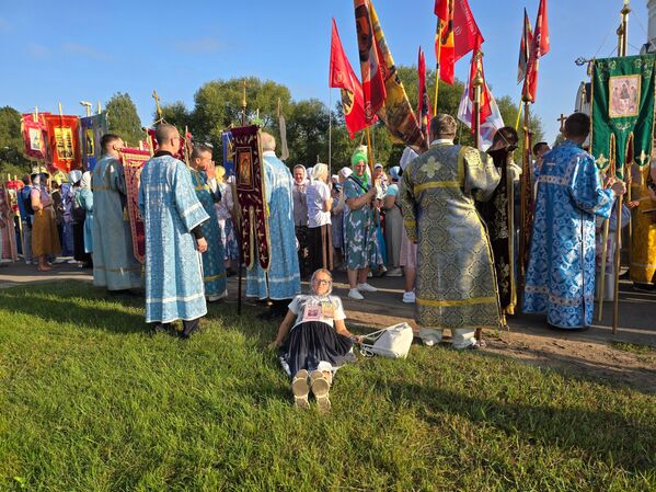 Паломніца стамілася і прылягла адпачыць, пакуль Хрэсны ход зноў не рушыў у дарогу. - Sputnik Беларусь