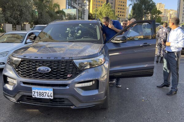 Полицейские осматривают автомобиль, внутри которого взорвался пейджер. - Sputnik Беларусь