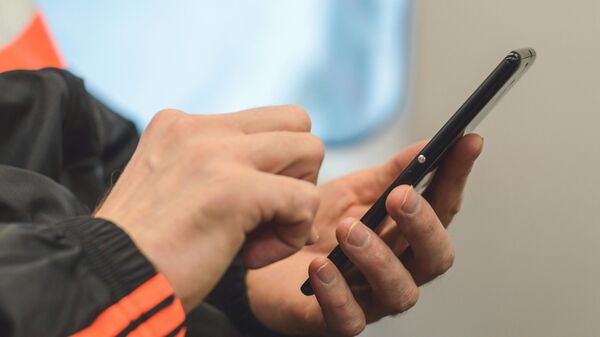 Мужчына трымае ў руках смартфон - Sputnik Беларусь