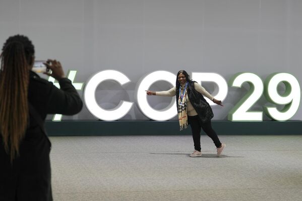 Девушка фотографируется на фоне логотипа саммита COP29 в Баку. Девушка фотографируется на фоне логотипа саммита COP29 в Баку. - Sputnik Беларусь