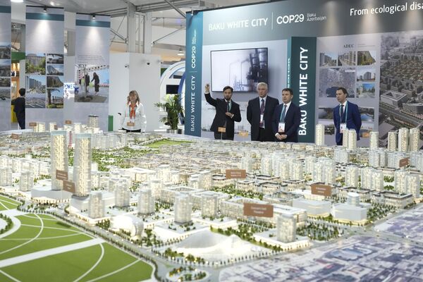 Люди смотрят на план комплекса недвижимости Baku White City, представленный на саммите COP29 в Баку, Азербайджан Люди смотрят на план комплекса недвижимости Baku White City, представленный на саммите COP29 в Баку, Азербайджан - Sputnik Беларусь